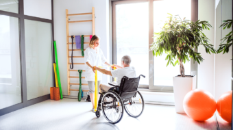 young-woman-physiotherapist-working-with-a-senior-PYSKN32